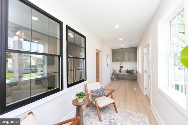 interior space featuring baseboards, recessed lighting, a healthy amount of sunlight, and light wood-style flooring