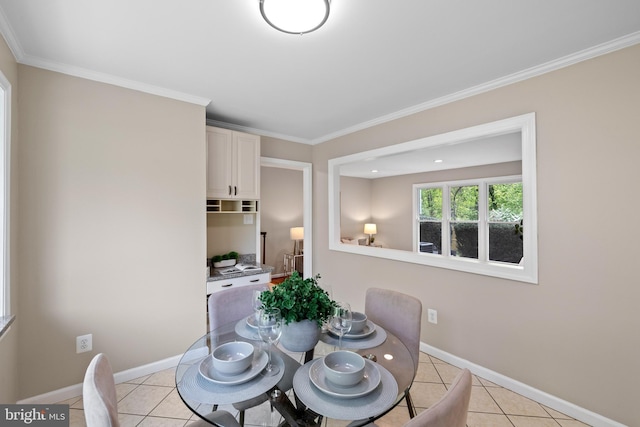 dining area with light tile patterned floors, crown molding, and baseboards