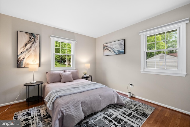 bedroom with baseboards and wood finished floors
