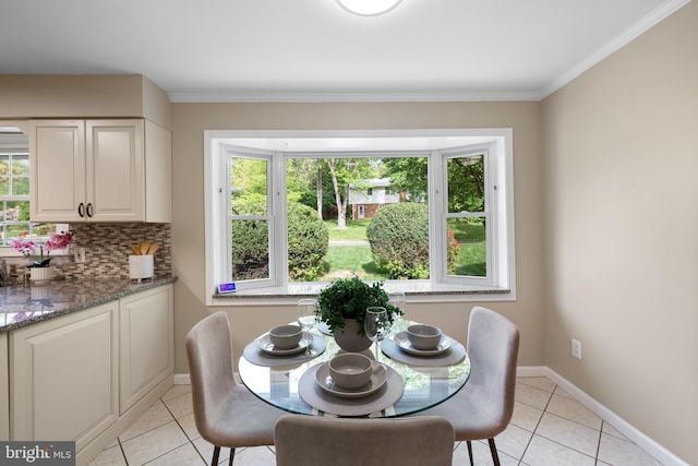 dining room featuring baseboards, light tile patterned floors, and ornamental molding