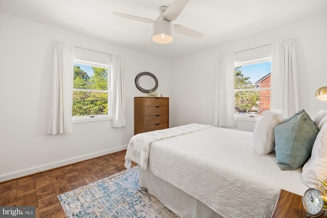 bedroom with a ceiling fan and baseboards
