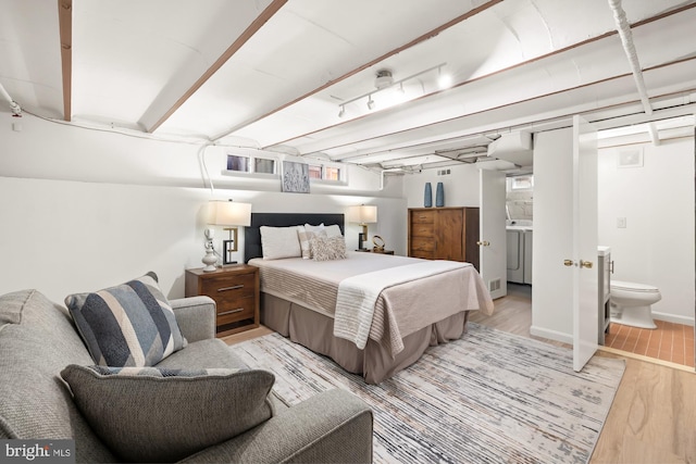 bedroom with visible vents, light wood finished floors, and washer / clothes dryer