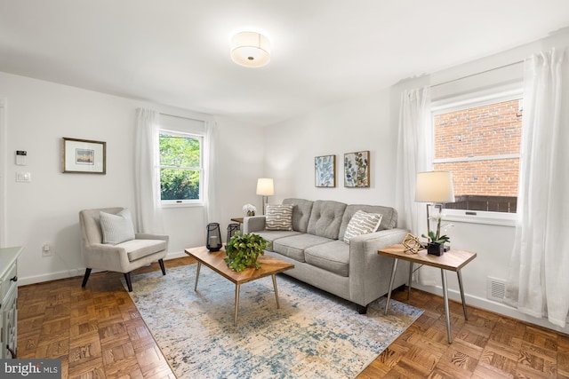 living area with baseboards and visible vents