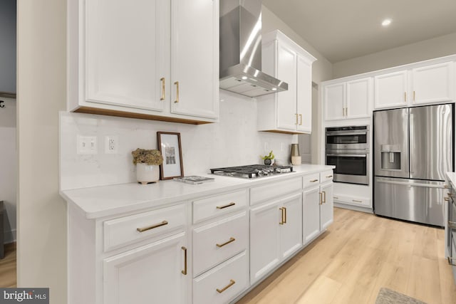 15613 Althea Ln, Gainesville, VA 20155 - kitchen with stainless steel appliances, wall chimney range hood, white cabinets, light wood-style flooring, and light countertops