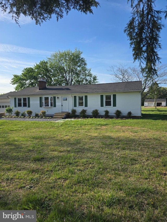 ranch-style house featuring a front lawn and a chimney