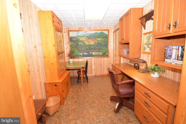 office featuring wooden walls and built in desk
