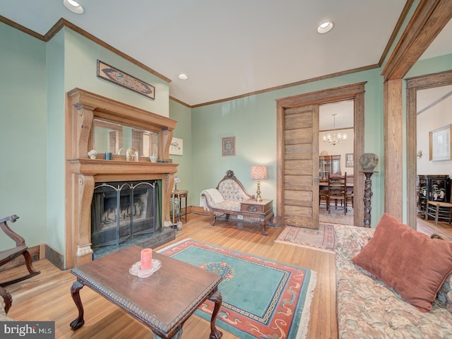 living area featuring crown molding, a fireplace with flush hearth, and wood finished floors