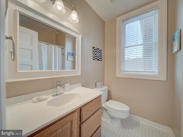 bathroom featuring vanity, toilet, tile patterned floors, baseboards, and lofted ceiling