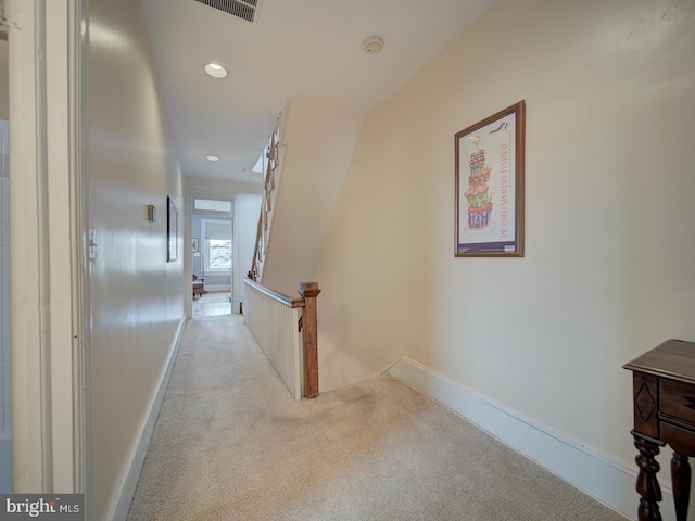 hallway with carpet floors, recessed lighting, baseboards, an upstairs landing, and visible vents