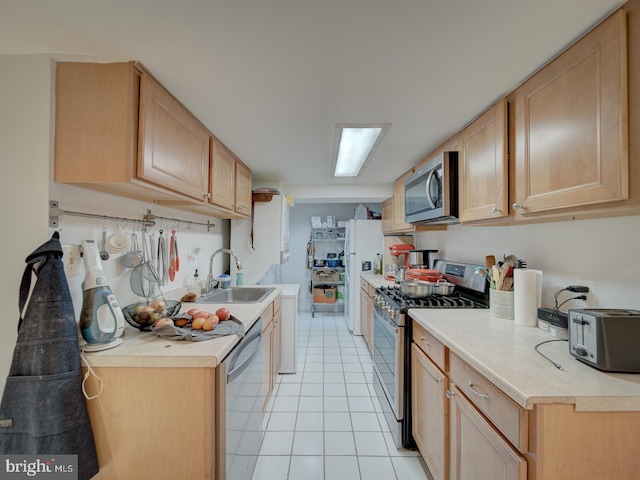 kitchen featuring appliances with stainless steel finishes, light tile patterned floors, a toaster, a sink, and light countertops