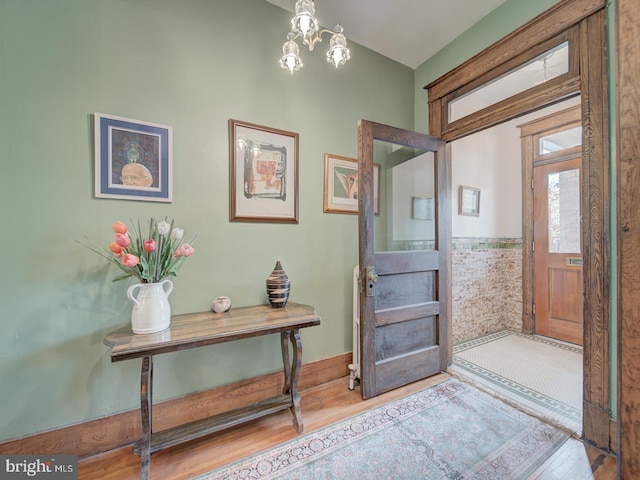 foyer featuring an inviting chandelier and wood finished floors