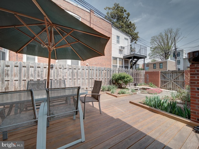 deck with a fenced backyard and outdoor dining area
