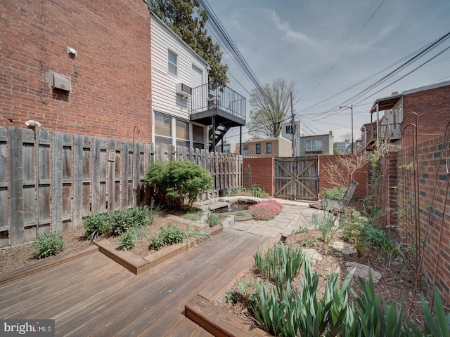 view of yard with a fenced backyard, a gate, and a deck