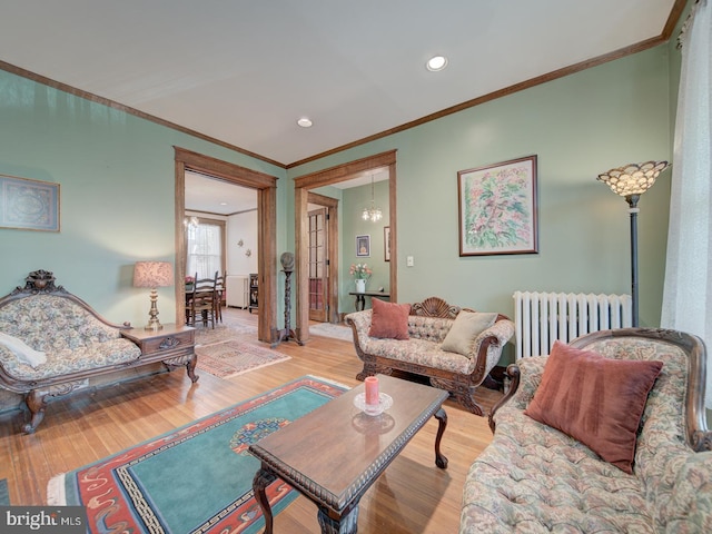 living room with crown molding, recessed lighting, radiator, and wood finished floors