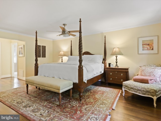 bedroom featuring wood finished floors, crown molding, and baseboards