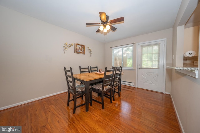 dining area featuring baseboards, ceiling fan, a baseboard heating unit, and wood finished floors