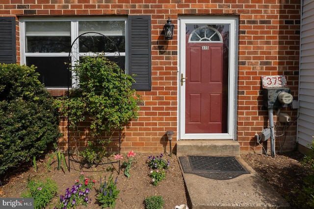 property entrance featuring brick siding