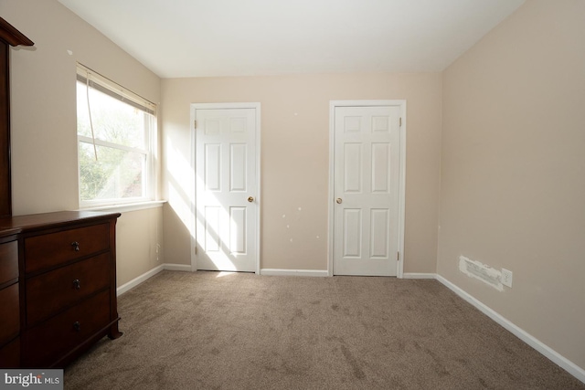 unfurnished bedroom featuring carpet floors and baseboards