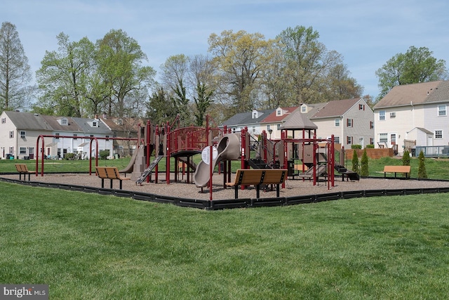 communal playground with fence, a yard, and a residential view