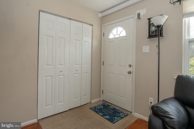 foyer entrance featuring light tile patterned floors and baseboards