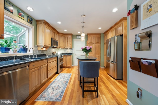 7228 Devereux Ct, Alexandria, VA 22315 - kitchen featuring stainless steel appliances, a sink, light wood-style flooring, backsplash, and decorative light fixtures