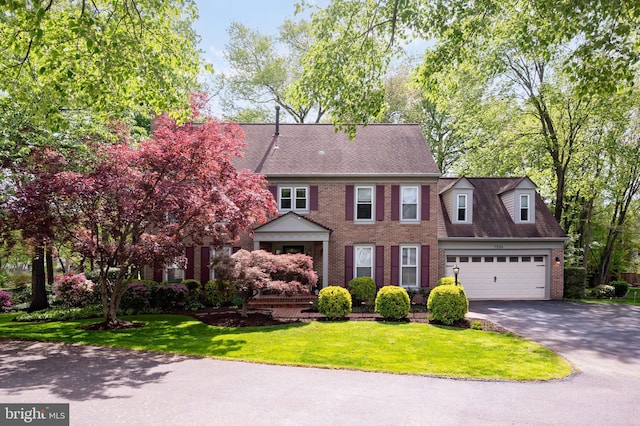 7228 Devereux Ct, Alexandria, VA 22315 - view of front facade with brick siding, asphalt driveway, a garage, and a front yard