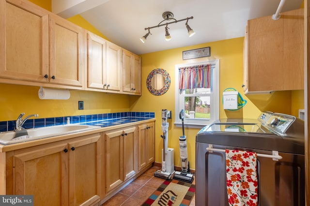 7228 Devereux Ct, Alexandria, VA 22315 - kitchen with washer and clothes dryer, a sink, dark tile patterned flooring, light brown cabinetry, and rail lighting
