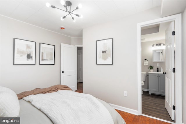 6217 Burgess Ave, Baltimore, MD 21214 - bedroom featuring ensuite bath, baseboards, a chandelier, and dark wood-type flooring