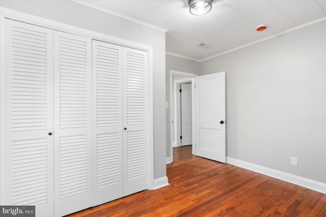 6217 Burgess Ave, Baltimore, MD 21214 - unfurnished bedroom with wood finished floors, visible vents, ornamental molding, a closet, and baseboards
