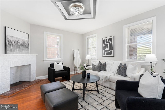 6217 Burgess Ave, Baltimore, MD 21214 - living area with baseboards, a brick fireplace, and wood finished floors