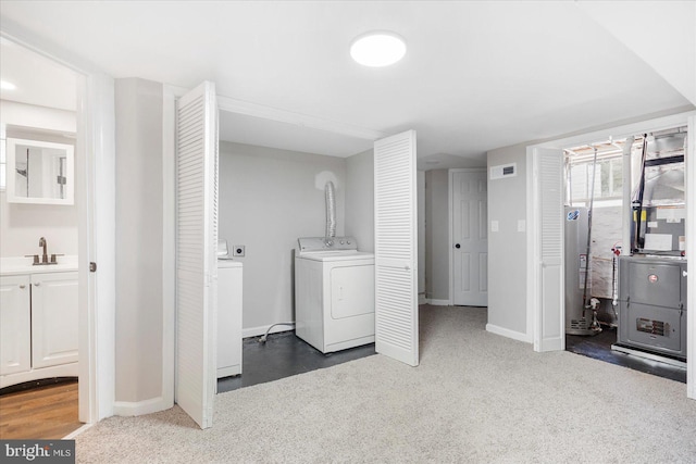 6217 Burgess Ave, Baltimore, MD 21214 - washroom featuring a sink, washer and clothes dryer, baseboards, water heater, and laundry area