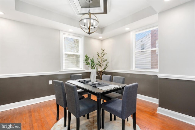 6217 Burgess Ave, Baltimore, MD 21214 - dining area featuring wood finished floors, a chandelier, a raised ceiling, and a healthy amount of sunlight