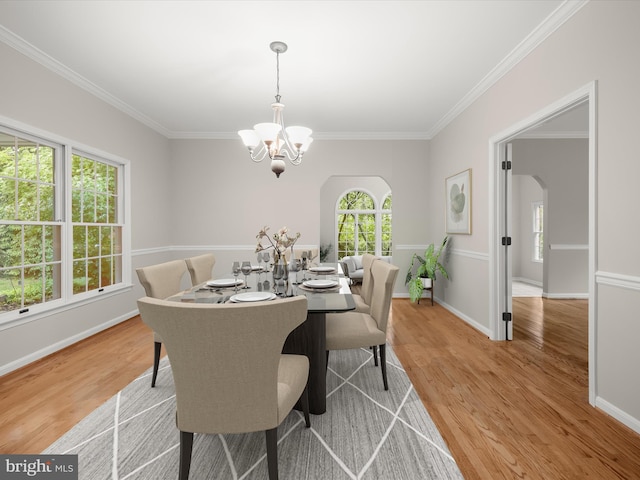 13148 Isle Of Mann Way, Highland, MD 20777 - dining room featuring a chandelier, arched walkways, light wood-style flooring, crown molding, and baseboards