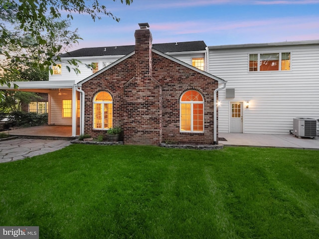 13148 Isle Of Mann Way, Highland, MD 20777 - view of front of property featuring a patio, a chimney, central AC unit, a lawn, and brick siding