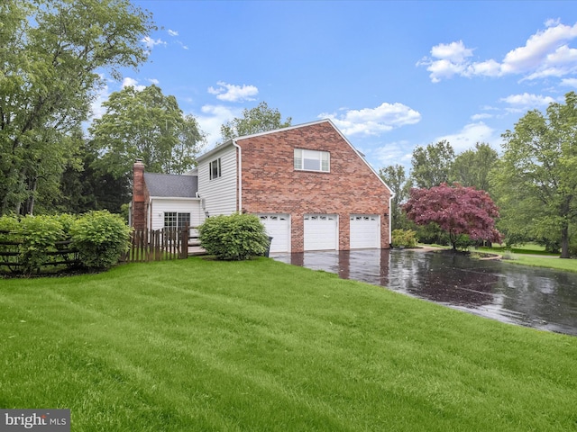 13148 Isle Of Mann Way, Highland, MD 20777 - view of property exterior with driveway, a garage, brick siding, and a chimney