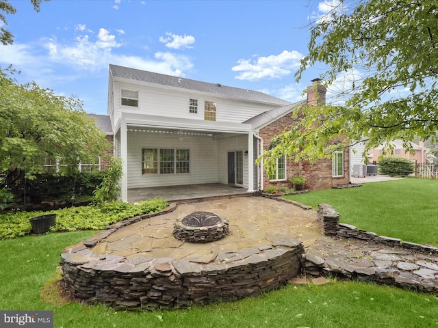 13148 Isle Of Mann Way, Highland, MD 20777 - rear view of house with a fire pit, a patio, a lawn, a chimney, and brick siding