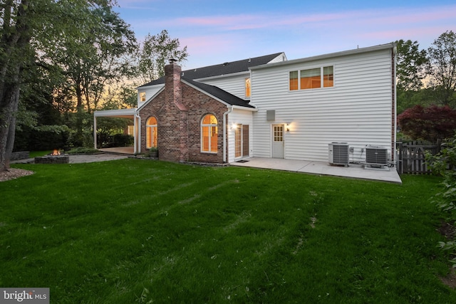 13148 Isle Of Mann Way, Highland, MD 20777 - back of property at dusk with a patio, central AC, and a chimney