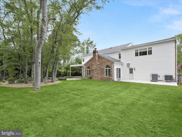 13148 Isle Of Mann Way, Highland, MD 20777 - back of house featuring a patio area, cooling unit, a yard, and a chimney