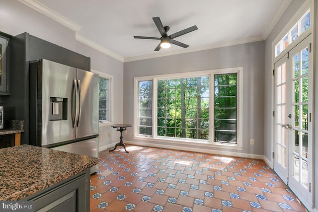 kitchen featuring stainless steel fridge, baseboards, a ceiling fan, and dark stone counters