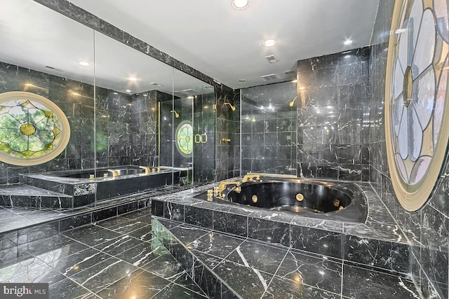 bathroom featuring recessed lighting, tile walls, marble finish floor, and a jetted tub