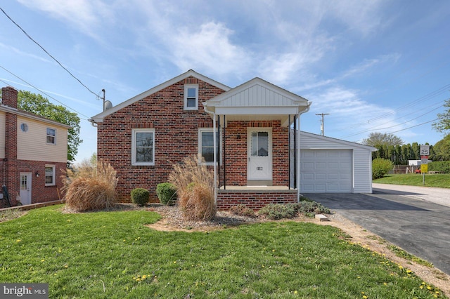 view of front facade with a front lawn, brick siding, and driveway