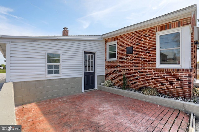 exterior space with a chimney and a patio