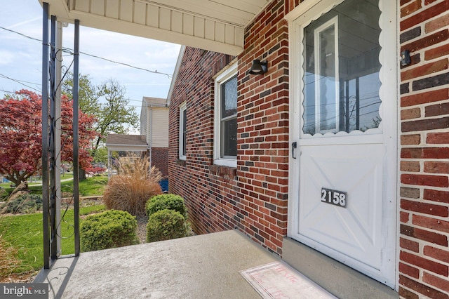 view of exterior entry featuring brick siding