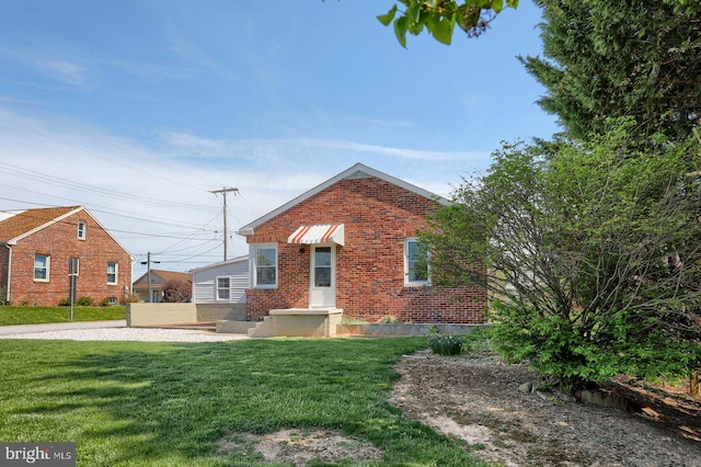 view of front of home with a front lawn and brick siding