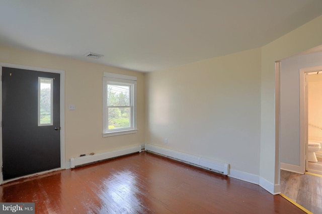 entrance foyer featuring a baseboard heating unit, baseboards, wood finished floors, and a wealth of natural light