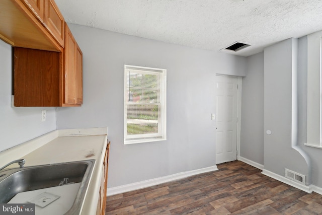 1714 Abbotston St, Baltimore, MD 21218 - kitchen with dark wood-style floors, a sink, brown cabinetry, baseboards, and a textured ceiling