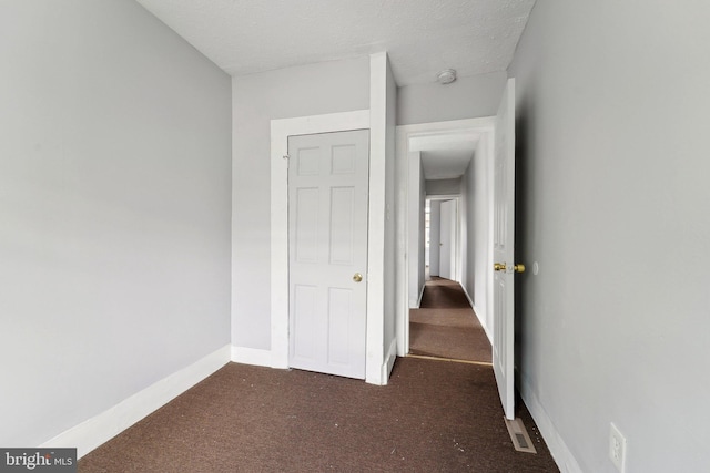 1714 Abbotston St, Baltimore, MD 21218 - hall featuring dark colored carpet, baseboards, and a textured ceiling