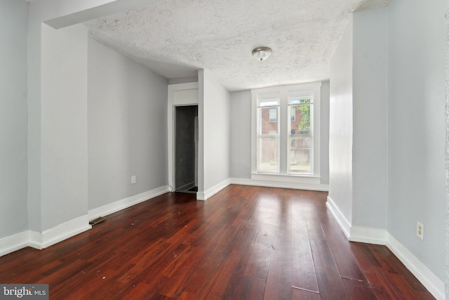 1714 Abbotston St, Baltimore, MD 21218 - unfurnished bedroom featuring dark wood finished floors, baseboards, and a textured ceiling