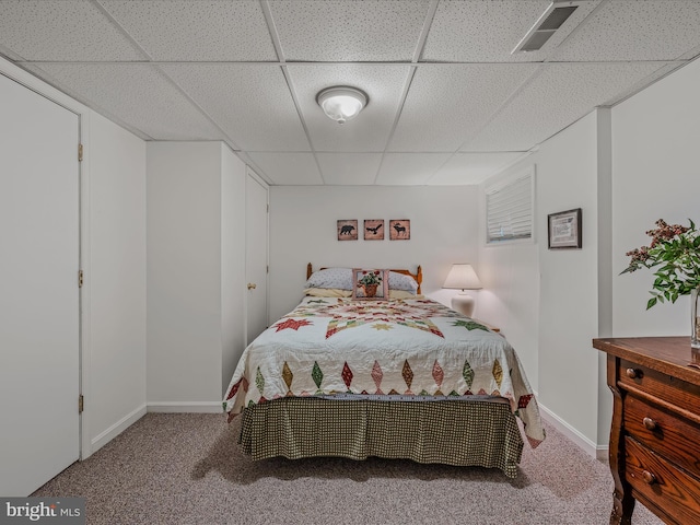 bedroom featuring carpet floors, a paneled ceiling, baseboards, and visible vents