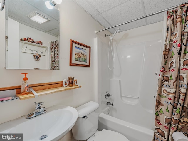 full bath featuring a sink, toilet, shower / bathtub combination with curtain, a paneled ceiling, and visible vents
